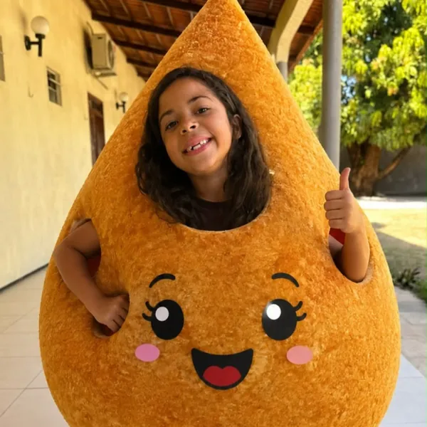 Menina fantasiada de coxinha gigante fazendo sinal de positivo